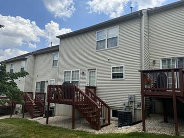 York apartment for rent - A beige building with a brown deck and stairs.