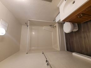 Mount Wolf apartment for rent - A white bathroom with a glass shower door.