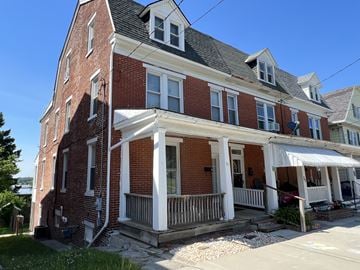 Red Lion apartment for rent - A red brick house with a white porch.