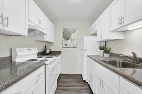 Dover apartment for rent - A kitchen with white cabinets and a granite countertop.