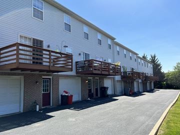 Red Lion apartment for rent - A long white building with a red door and a balcony.