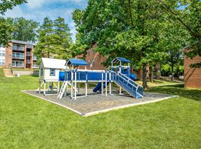 York apartment for rent - A playground with a blue slide and a white building in the background.