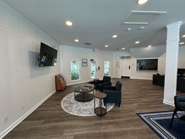 Virginia Beach apartment for rent - A living room with a black coffee table and a flat screen TV mounted on the wall.