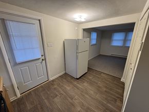 Windsor apartment for rent - A kitchen with a white fridge and wooden floors.