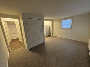 Windsor apartment for rent - A room with a carpeted floor, a white door, and a window with blinds.