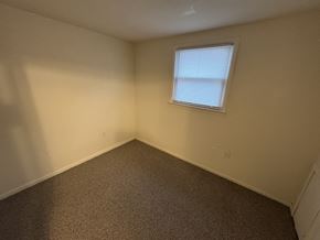 Windsor apartment for rent - A room with a carpeted floor and a window with blinds.
