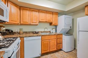 York apartment for rent - A kitchen with wooden cabinets and white appliances.
