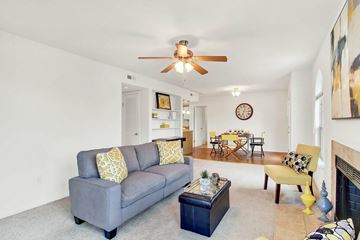 Virginia Beach apartment for rent - A living room with a grey couch and a yellow pillow.