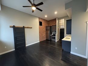 Red Lion apartment for rent - A room with a ceiling fan and a brick wall.