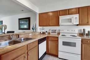 Richmond apartment for rent - A kitchen with wooden cabinets and a white stove.