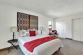Manchester apartment for rent - A bedroom with a large bed and a wooden headboard.