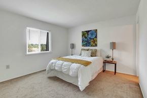 Harrisburg apartment for rent - A bedroom with a large bed and a painting on the wall.