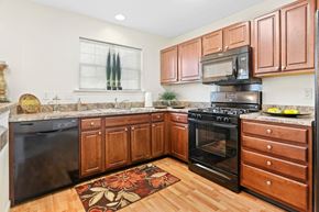 Harrisburg apartment for rent - A kitchen with wooden cabinets and a black stove top oven.