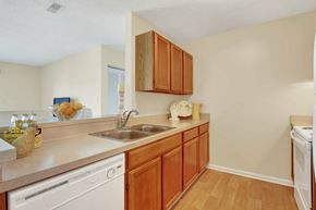Fredericksburg apartment for rent - A kitchen with wooden cabinets and white appliances.