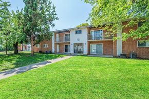 Harrisburg apartment for rent - A grassy area in front of a brick apartment building.
