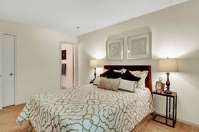 Glenallen apartment for rent - A bedroom with a patterned bedspread and two lamps on a side table.