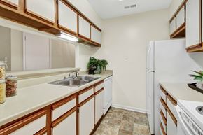 Glenallen apartment for rent - A kitchen with white appliances and wooden cabinets.