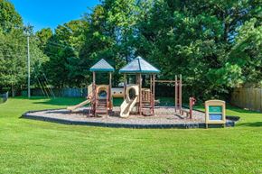 Suffolk apartment for rent - A playground with a slide, swings, and a roundabout.