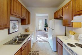 Suffolk apartment for rent - A kitchen with wooden cabinets and a white fridge.