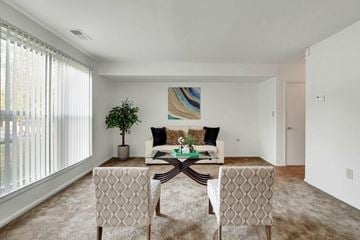 Harrisburg apartment for rent - A living room with a white couch, a green plant, and a painting on the wall.