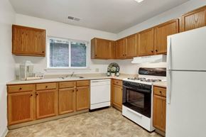 Harrisburg apartment for rent - A kitchen with wooden cabinets and white appliances.