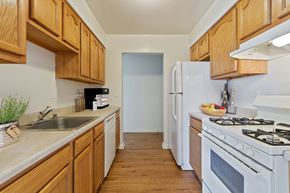 Hagerstown apartment for rent - A kitchen with wooden cabinets and a white refrigerator.