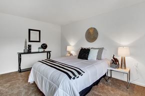 Hagerstown apartment for rent - A bedroom with a large bed and a mirror on the wall.