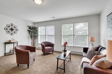 Hagerstown apartment for rent - A living room with a brown chair and a grey couch.