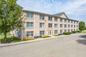 Hagerstown apartment for rent - A large brick building with a parking lot in front.