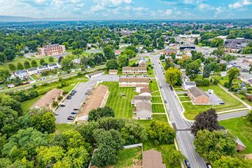 Hagerstown apartment for rent - A bird's eye view of a residential area with houses, trees, and a parking lot.