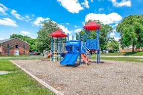Hagerstown apartment for rent - A playground with a blue slide and red roofed structure.