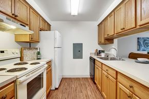 Hagerstown apartment for rent - A kitchen with wooden cabinets and a white stove top oven.