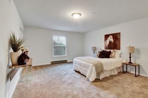 Hagerstown apartment for rent - A bedroom with a large bed and a painting on the wall.