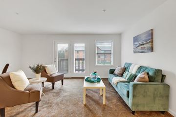 Hagerstown apartment for rent - A living room with a green couch and brown armchairs.