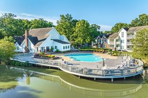 Richmond apartment for rent - A large house with a pool is surrounded by trees.