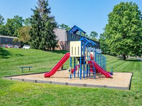 Harrisburg apartment for rent - A playground with a red slide and a blue and yellow structure.