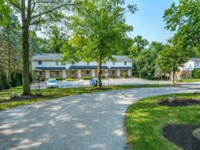 Dallastown apartment for rent - A white house with a driveway and trees in front.