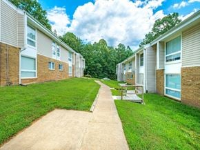 Chester apartment for rent - A row of houses with a concrete pathway leading to a picnic table.