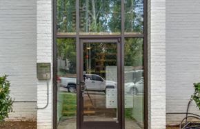 Nashville apartment for rent - A white building with a brown door and glass window.