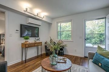 Nashville apartment for rent - A living room with a brown table and a television on the wall.