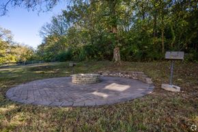 Nashville apartment for rent - A circular brick patio with a stone fireplace in the middle.
