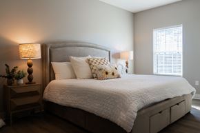 Biloxi apartment for rent - A bedroom with a large bed and a nightstand with a lamp.