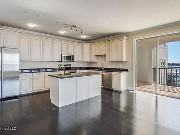 Biloxi apartment for rent - A kitchen with white cabinets and black countertops.