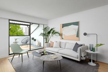 Vancouver apartment for rent - A living room with a white couch, a green chair, and a painting on the wall.