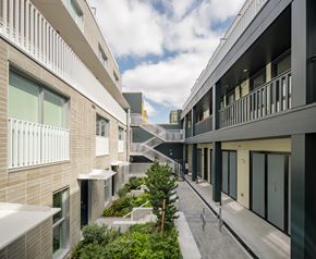 Vancouver apartment for rent - A modern building with a balcony and a tree in front.
