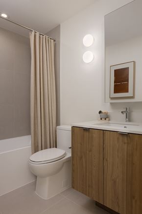Vancouver apartment for rent - A bathroom with a toilet, sink, and shower curtain.