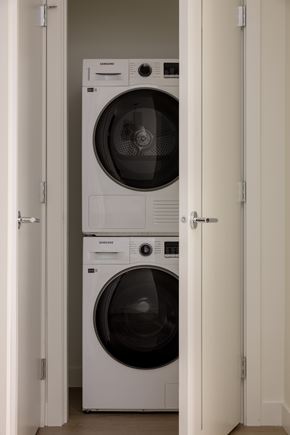 Vancouver apartment for rent - Two white front loading washing machines in a small room.