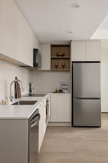 Vancouver apartment for rent - A modern kitchen with a stainless steel refrigerator and a white countertop.