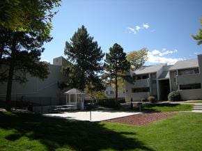 Englewood apartment for rent - A white gazebo sits on a patio surrounded by trees.