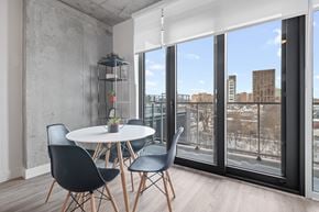 Ottawa apartment for rent - A dining room with a white table and black chairs.